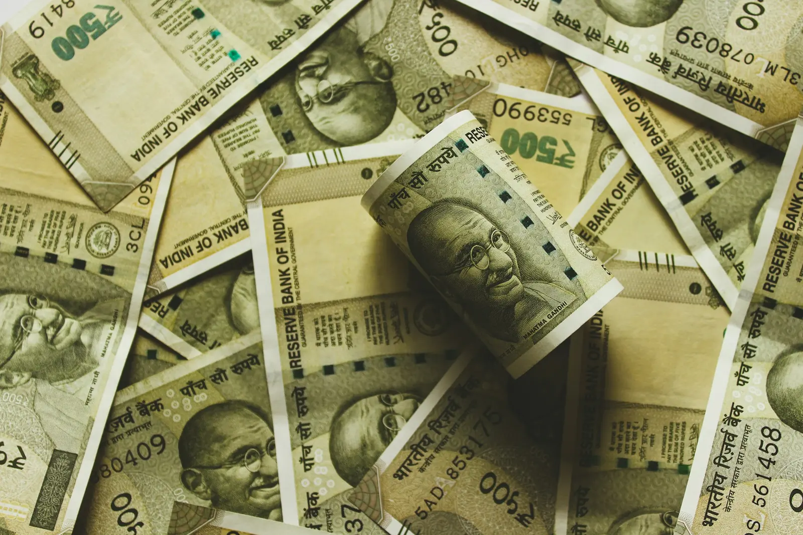 Pile of ₹500 notes with a rolled bundle on top